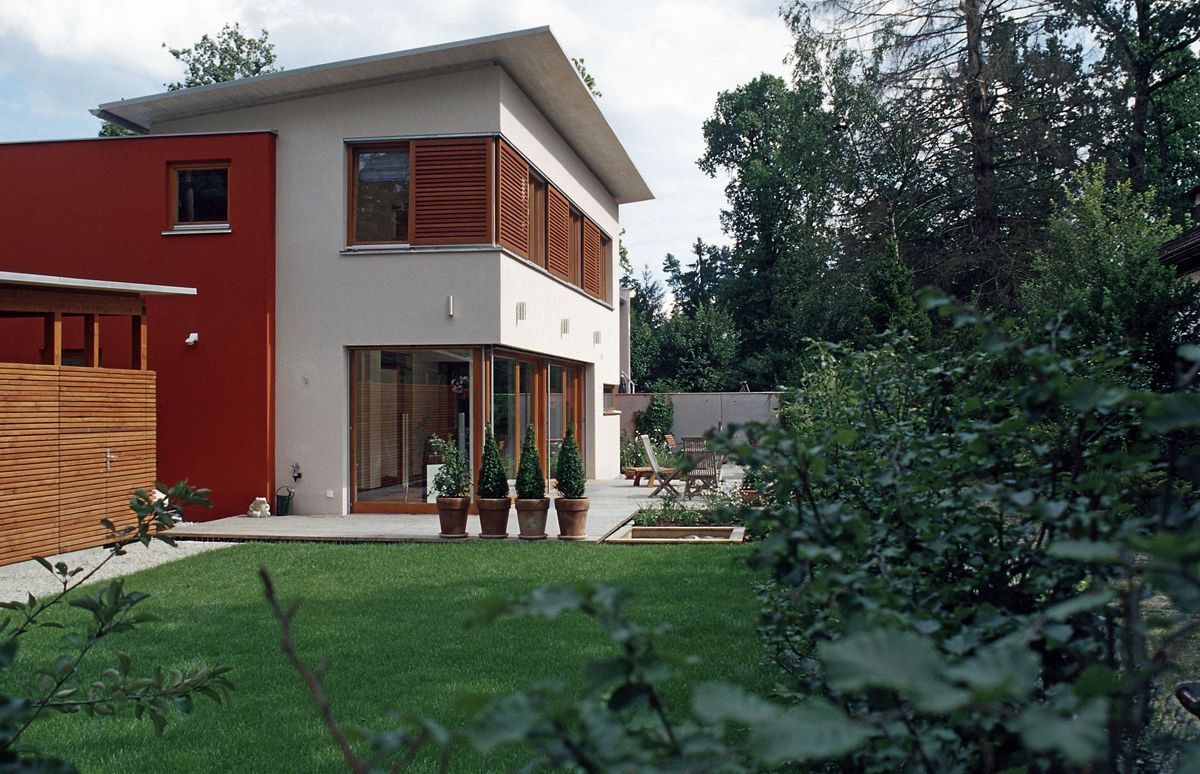 Seitenansicht eines weißen, einstöckigen Hauses mit braunen Fensterläden